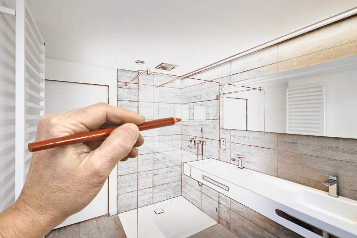 Architecte dintérieur présentant des plans de salle de bain à un client, discussion autour de matériaux et agencements.